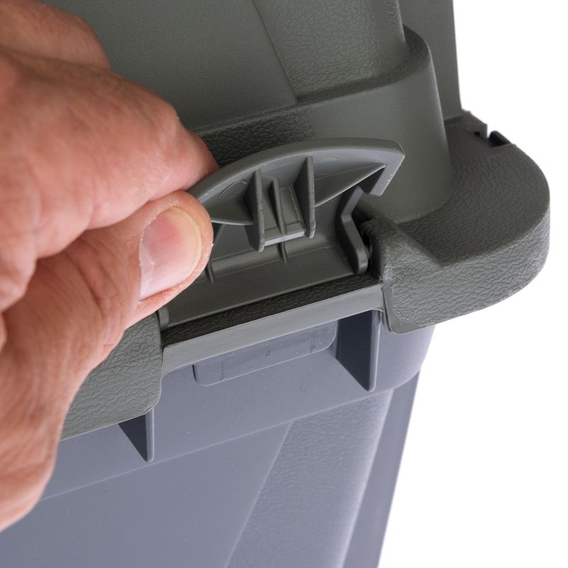 Hand opening the clasp of a grey plastic container with a green lid.