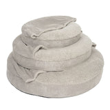 Three grey, round pet beds made of soft cord and plush material, stacked in different sizes.