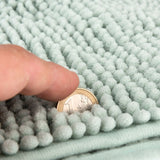 Close-up of a light green textured mat with a finger and a 1-euro coin to show material thickness.