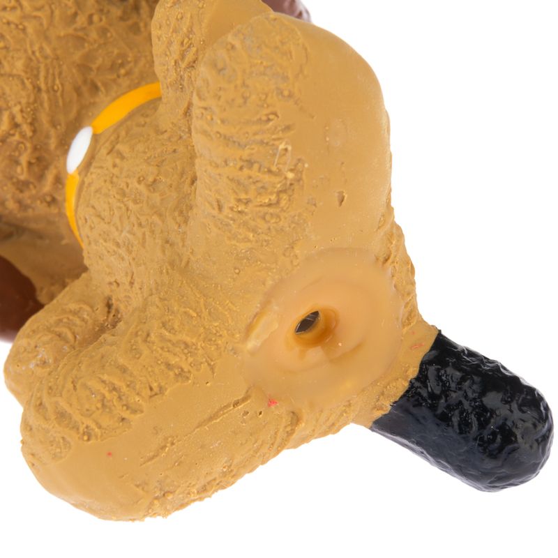 Close-up of a yellow plastic dog toy with a black nose and a hole for airflow or sound effect.