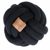 Black knotted fabric ball with brown leather label, inscription 'Modern Living'.