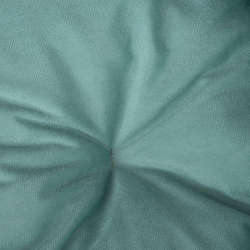 Close-up of green fabric with fine weave texture and a central crease.