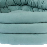 Close-up of a padded, turquoise pet bed with a soft fabric cover.