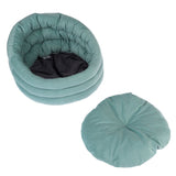 Round, padded pet bed in turquoise with removable cushion. Black, breathable inner material.