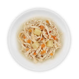 Close-up of shredded chicken with carrot and potato pieces in broth, served on a white plate.