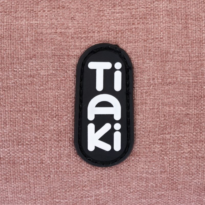 Tiaki. Brand logo on pink fabric background.