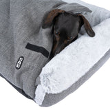 Tiaki dog blanket in grey with soft white plush inner side. Dachshund partially under the blanket.