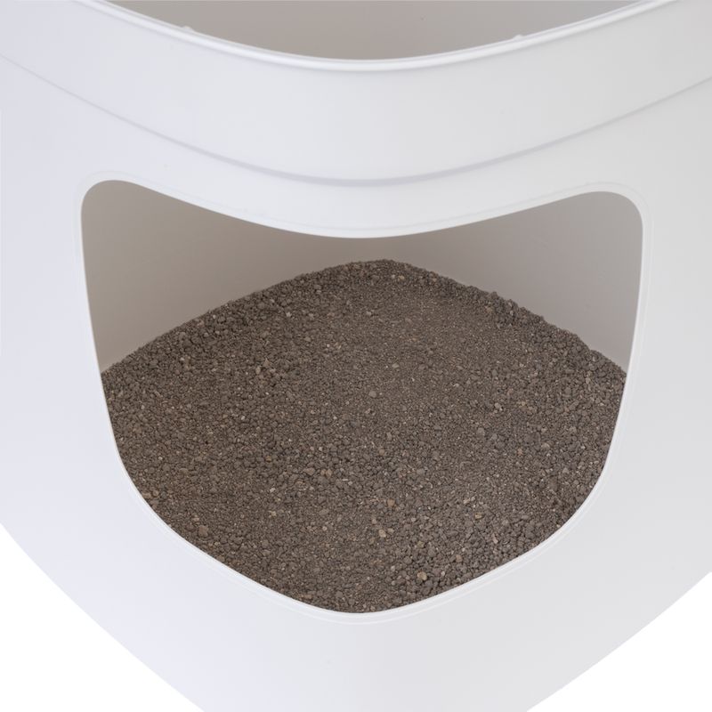Close-up of a white cat litter box with grey cat litter inside.
