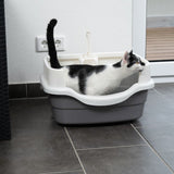 Black and white cat in a grey litter tray with white rim and integrated scoop holder. Product shows use of the litter tray.