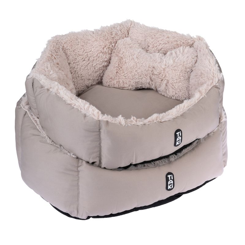Round, beige pet bed with soft plush lining and Tiaki logo on the outside.