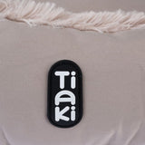 Tiaki logo on beige fabric with faux fur trim.