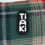 Tiaki logo on green checked fabric.