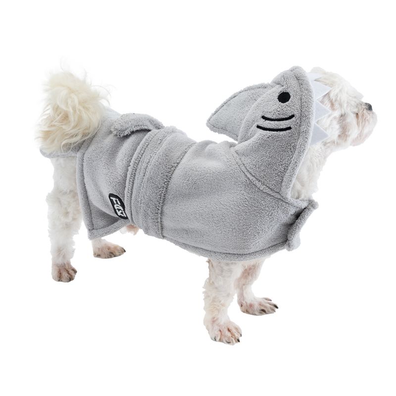 Dog wearing grey shark hooded coat with fins and teeth, Trixie brand visible on the side.