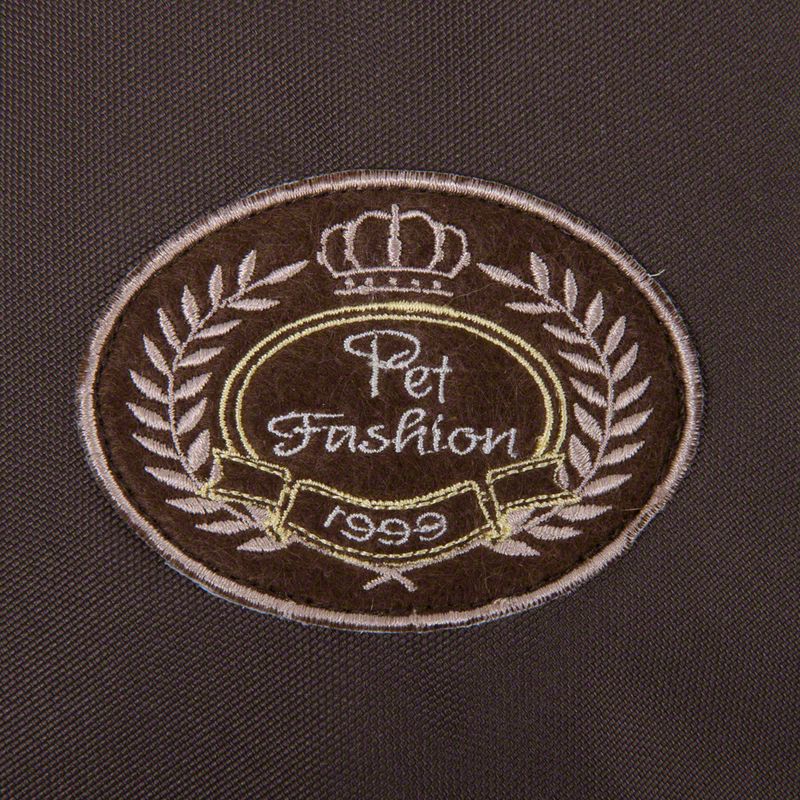 Pet Fashion 1999, embroidered emblem with crown and laurel wreath on brown fabric.