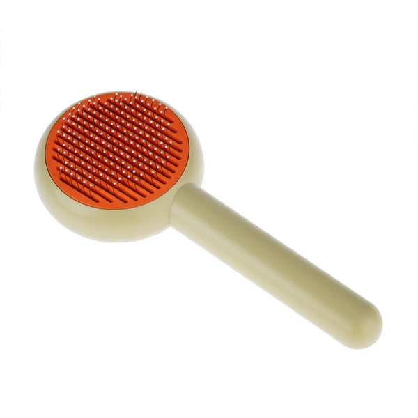 Round brush with orange head and beige handle, fine metal bristles for coat care visible.