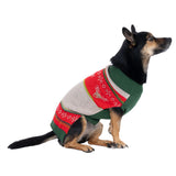 Dog wearing a knitted jumper in green, red and beige with reindeer and snowflake pattern.