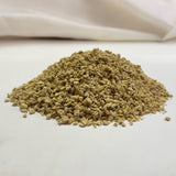 Close-up of loose, light brown granules on a white surface.