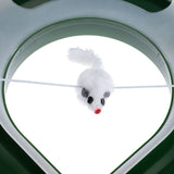 Toy mouse made of white plush with red and black accents, suspended on an elastic cord in a green frame.