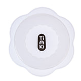 Tiaki. White lid with wavy edge and black logo in the centre.