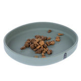 Round, green feeding bowl with dry food pieces. Bowl made of smooth material, brand logo 'Tia' visible on the rim.