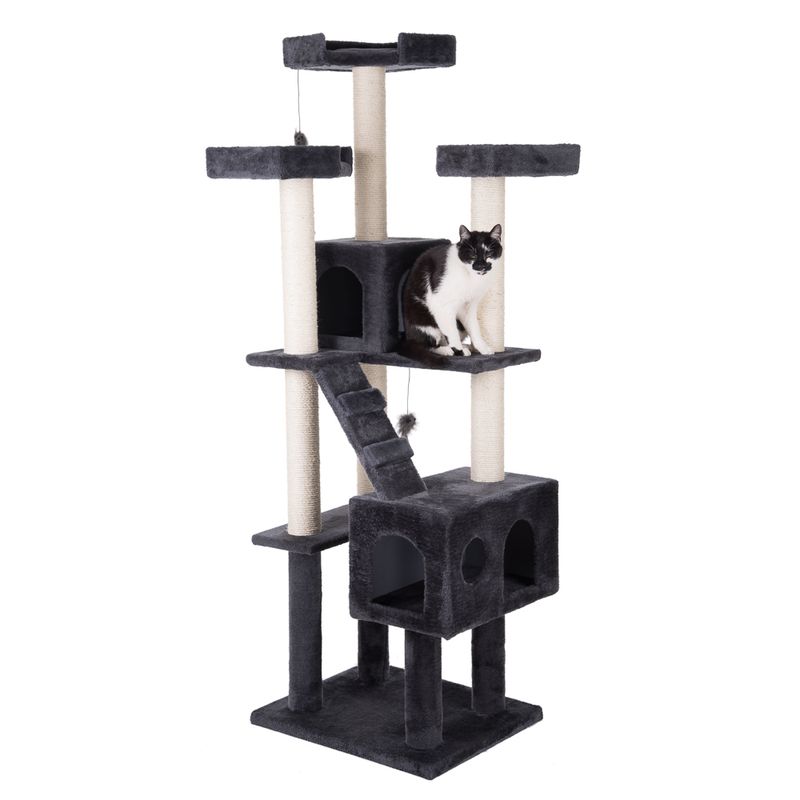 Cat tree with multiple levels, caves and sisal posts. Black and white cat sitting on a platform. Toy pendant visible.