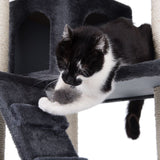 Black and white cat playing on a grey scratching post with plush surface and sisal posts.