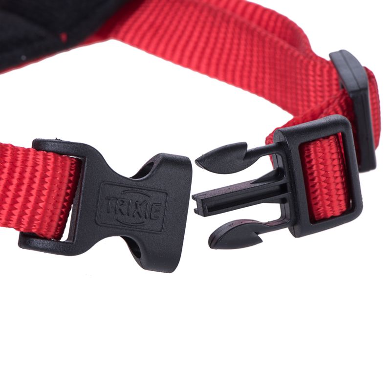 Red nylon strap with black click fastener, brand Trixie, close-up of fastening mechanism.