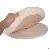 Hand showing removable beige-white cushion with hook-and-loop fastener on a round wooden board.