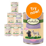 Lukullus Junior tinned dog food, visible flavours include turkey hearts & lamb, chicken & veal, poultry & game, 400g cans. Large orange badge reads 'Try now!'.