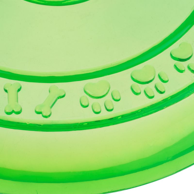 Green plastic frisbee with embossed bone, heart and paw motifs on the surface.