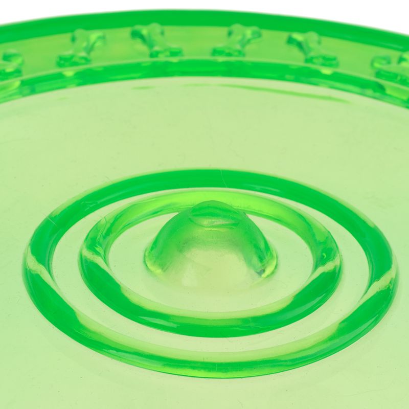 Green plastic toy with circular bumps and bone patterns on the edge, suitable for interactive play.