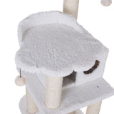 Cat tree with white plush cover, cave and platform. Sisal-wrapped posts and hanging toy visible.