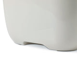 Close-up of a white plastic container with rounded corners and a recess at the bottom.