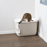 Cat toilet with white lid and integrated litter scoop, cat using the toilet.