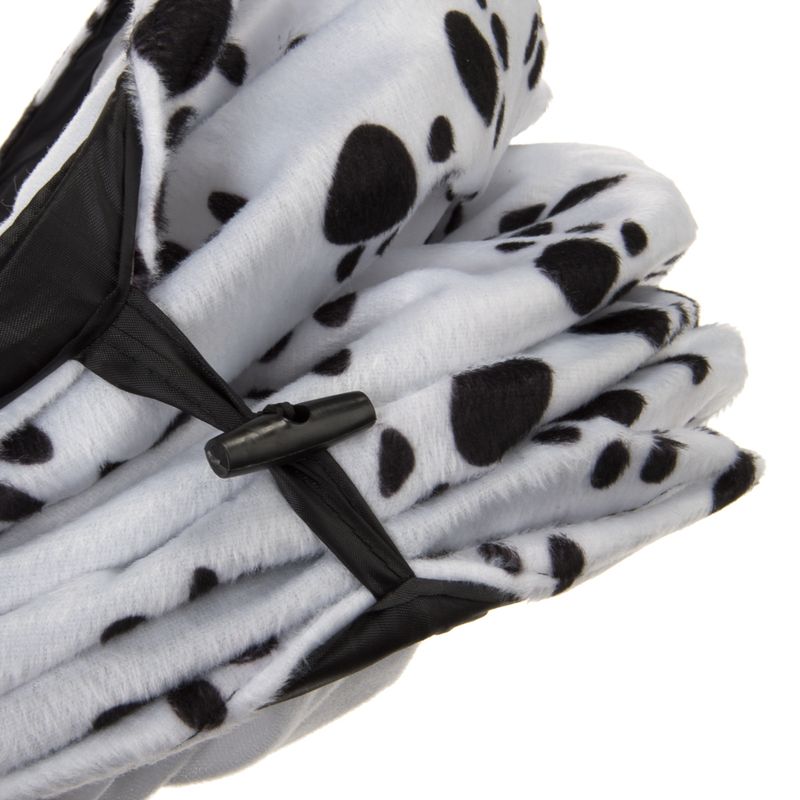 Folded dog blanket with Dalmatian pattern, white with black spots, and a black fastening strap.