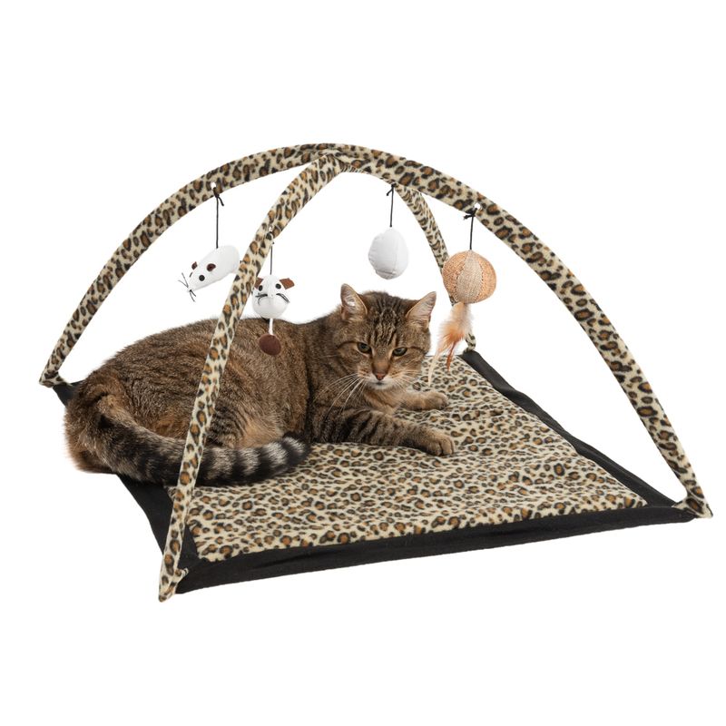 Leopard print play mat with arches and hanging toys, including mice, balls and feathers. Cat lying on the mat.