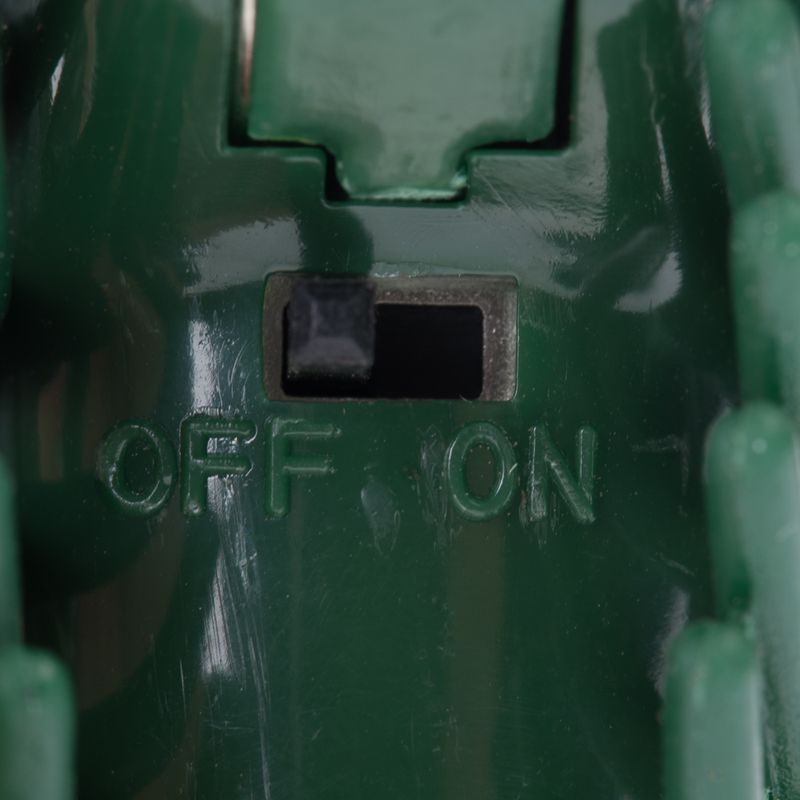 Close-up of a green switch with the labels OFF and ON.