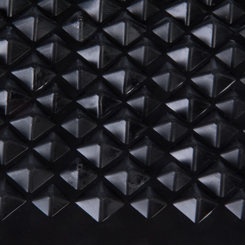 Close-up of a black surface with pyramid-shaped elevations, possibly material structure of a product.