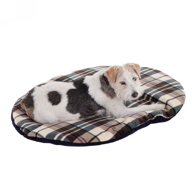 Dog lying on an oval dog cushion with a checked pattern in beige, brown and dark green.