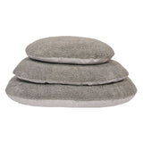 Three grey, fluffy cushions in different sizes stacked on top of each other. Suitable for comfort and relaxation.