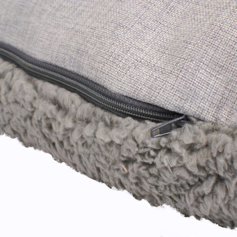 Close-up of a grey cushion with zip and soft, fluffy faux fur underside.
