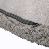 Close-up of a grey cushion with zip and soft, fluffy faux fur underside.