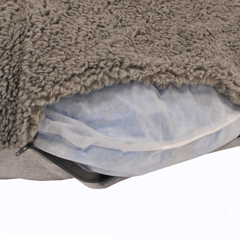 Close-up of a grey pet cushion with removable cover and visible inner filling made of mesh material.