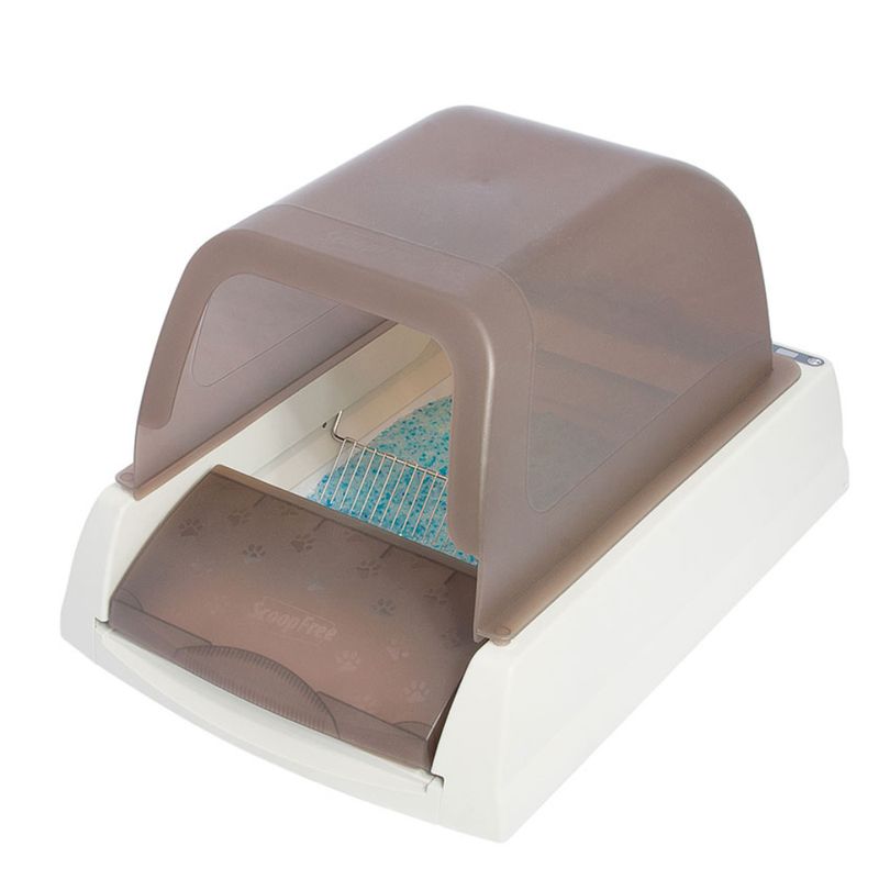 Covered automatic litter box with a transparent brown hood, sliding tray, and blue absorbent crystals visible inside.