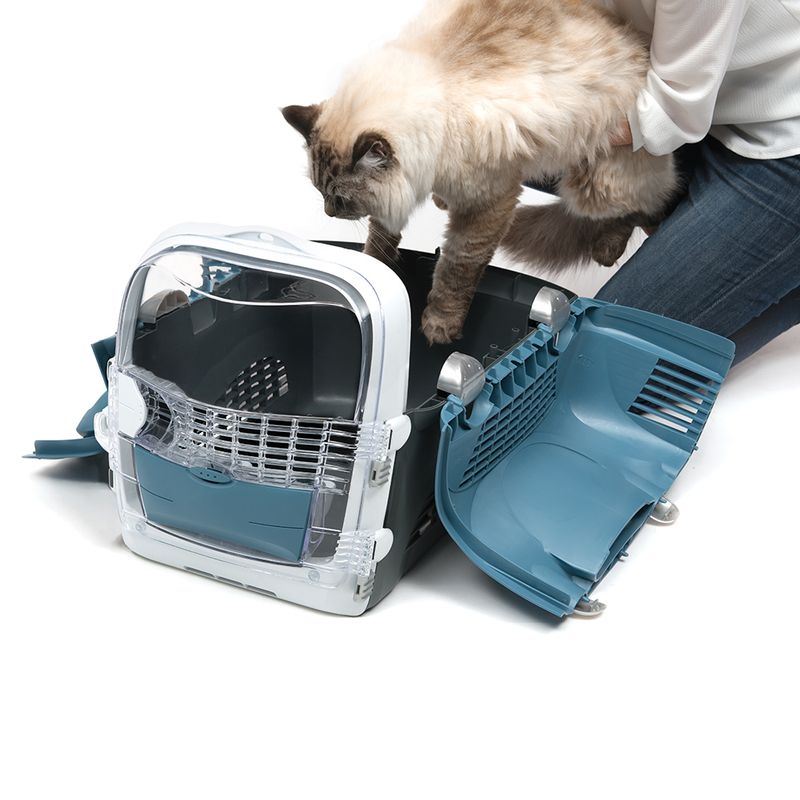 Transport box with side-opened door, cat being placed inside. Suitable for pet transport and easy handling with folding mechanism.