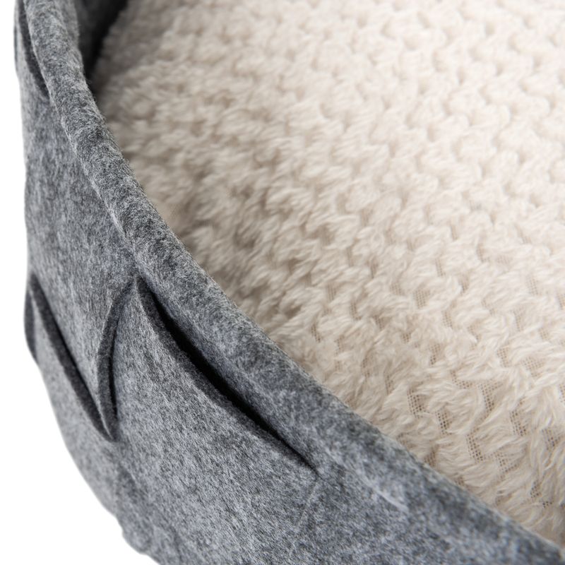 Close-up view of a grey felt basket with cream-coloured, textured inner padding.