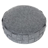 Round grey cushion with braided edge made of felt material, suitable as a decorative or functional accessory.