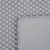Close-up of grey, textured fabric with woven pattern and smooth edge. Shows material details for product description.