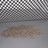 Close-up of cat litter on a grey, textured surface with a chequered background.