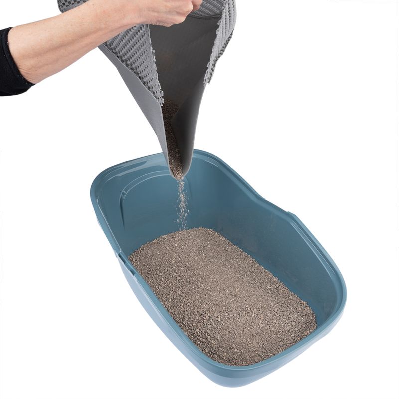 Grey mat used to pour cat litter into a blue cat toilet.